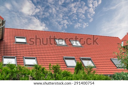 House roof with red roof tiles and skylights