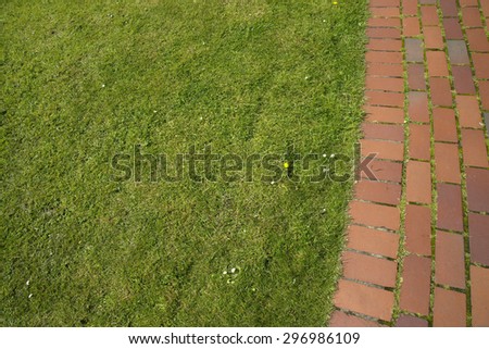A brick pathway next to a grass area