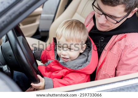 Dad teaches son to drive. Kid in focus.