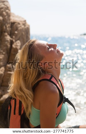 Adventure girl playing with her hair on the wild coast