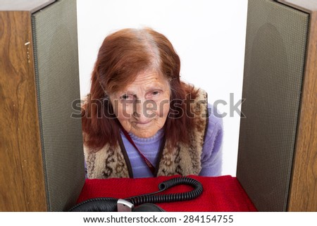 Elderly lady putting her head  between Audio Speakers to hear better