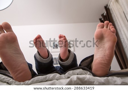 Father is with his son in bed. Naptime, Like father, like son ....