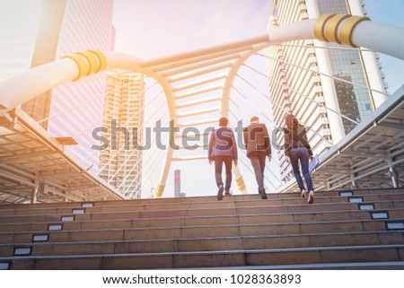 Rear view of business team climbing stairs go to a city. Business concept
