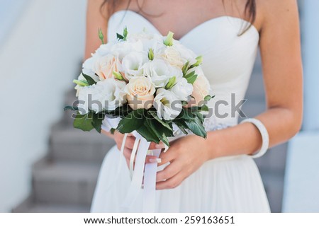 Beautiful wedding bouquet of flowers in hands of the bride