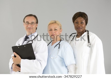 Three self confident medical specialists smiling and looking at the camera