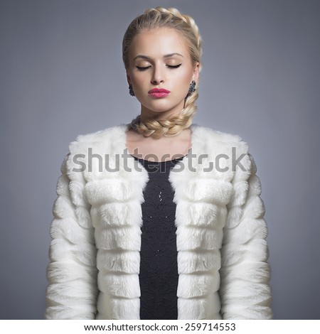 Beautiful blond woman in Fur Coat.Winter fashion.Pretty Girl model in jewelry
