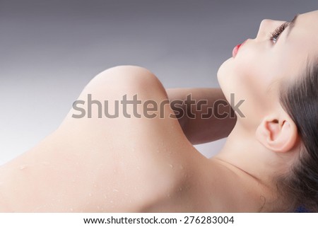wet shoulder of a young woman showing skin detail and the way the water condenses and beads on the surface of the skin.spa