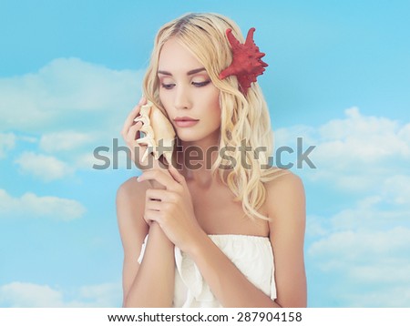 beautiful blond girl listening a shell. sea sun summer concept.fantastic nymph woman.fashion art portrait.starfish hairstyle