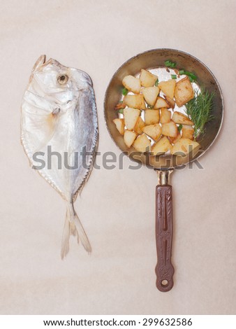 unusual art still life. Dried fish and Fried potatoes in a pan