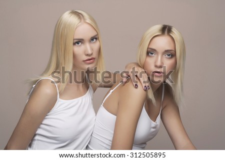 Two young beautiful woman twins blonde. sexy twins couple.girls