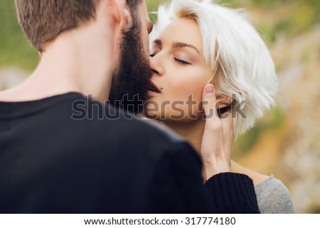 Lovely kissing couple.romantic beautiful woman and handsome man.bearded boy and blond girl outdoor together