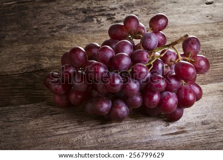bunch of rose grapes on wooden desk