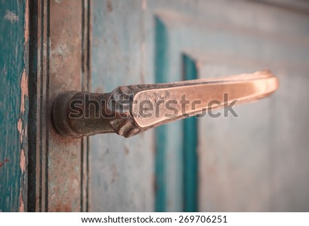 Old bronze door handle on a aged wooden door