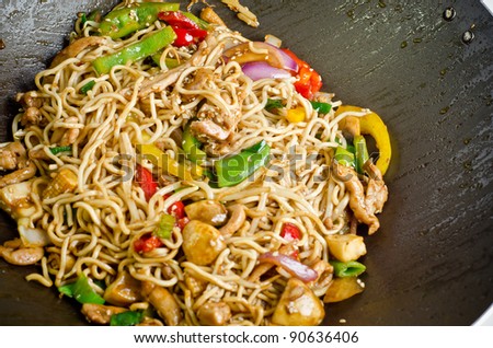 Stir fry noodle with chicken in a wok pan