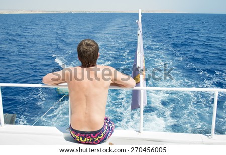 Photo of the man on yacht look at the water in high Red sea, Egypt,  Africa,