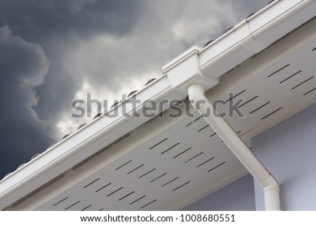 white plastic rain gutter and dark sky. concept : preparing maintenance rain gutter before rainy season.