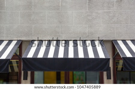 black and white awning over the glass window of shop, canvas shading decoration for coffee shop