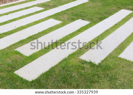 green grass and concrete bar use for foot step on pathway in garden, modern style for garden decoration