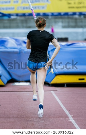 A female athlete competing in the pole vault at a track and field event