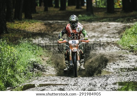 Kyshtym, Russia - June 21, 2015: Motocross driver under the spray of mud during the race Urals Cup of Enduro 