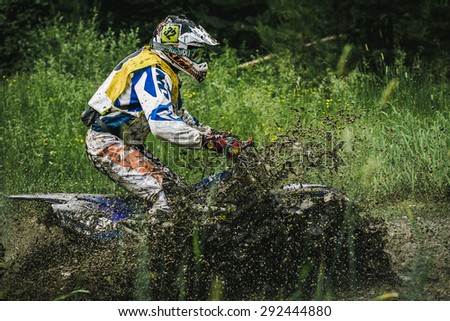Kyshtym, Russia - June 21, 2015: Motocross driver under the spray of mud during the race Urals Cup of Enduro \