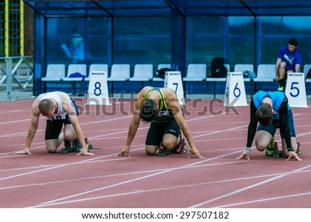 Chelyabinsk, Russia - July 10, 2015: sprinters on the start line 100 m during Championship of Chelyabinsk on track and field athletics, Chelyabinsk, Russia - July 10, 2015