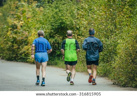 Chelyabinsk, Russia - September 6, 2015: Vroup of older men running down the road in the Park during Chelyabinsk marathon, Chelyabinsk, Russia - September 6, 2015