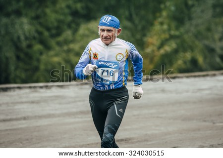 Omsk, Russia -  September 20, 2015: elderly man athlete runs along waterfront during Siberian international marathon