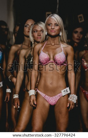 Chelyabinsk, Russia - October 3, 2015: female athlete blonde fitness bikini stands in face forward position during Championship of Chelyabinsk region on bodybuilding, bodyfitness and fitness