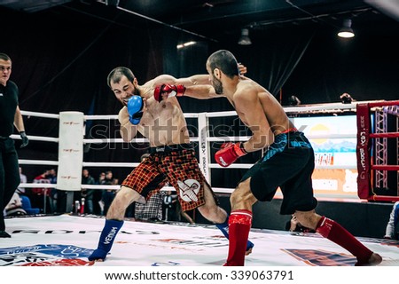 Volgograd, Russia - October 24, 2015: mixed martial arts fighter deals a direct blow to hand on head of opponent during Championship of Russia on mixed martial arts