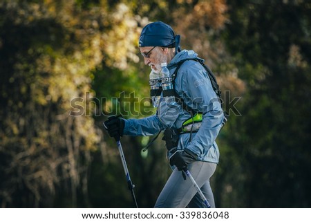 Yalta, Russia - October 31, 2015: old athlete is distance of race, with a backpack and water bottles during First Yalta mountain marathon