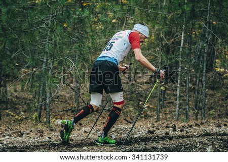 Yalta, Russia - November 2, 2015: athlete running with nordic walking poles in compression socks during Mountain marathon \