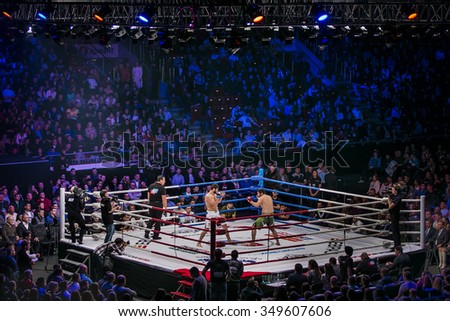 Chelyabinsk, Russia - December 5, 2015: General plan of sports arena during fight in ring, fighters and referee across ring fans during Cup of Russia MMA