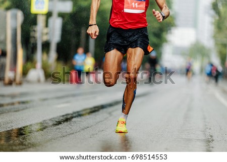 leader athlete runner running city marathon in rain
