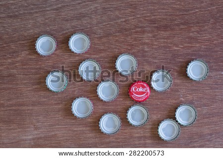 Friday, 29 May 2015: in Chiang Mai Thailand ,Coca Cola Bottle Caps on wood table.