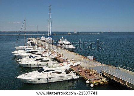 Expensive white yachts and motor boats lined up at the marina