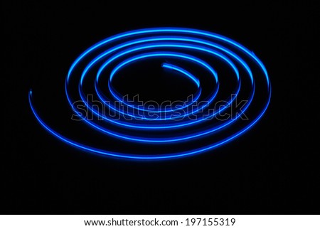 Blue neon stripe is isolated on the black background