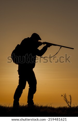 Hunter prepares to shoot wild boar sunset