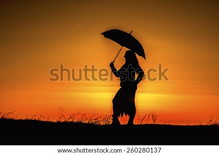 Young girl with an umbrella in the sunset