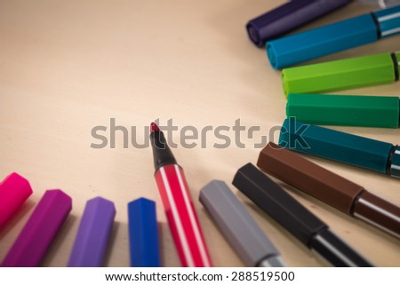 red pens drive focus to center on wooden backround