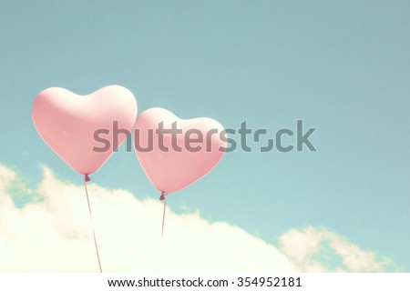 Pink coral heart balloons over a pastel blue sky