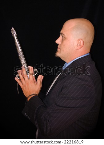 Man in business suit against dark background holding a medieval dagger