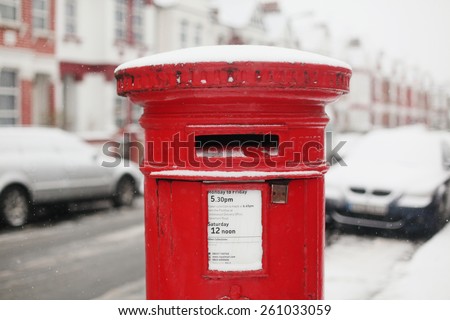A typical English red letter (post) box covered in snow on the street of London.\
10th of January, 2013