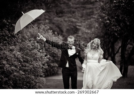wedding couple in rain with umbrella