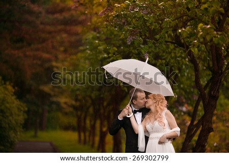 wedding couple in rain with umbrella