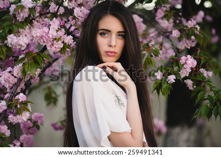 Beautiful girl near Oriental cherries