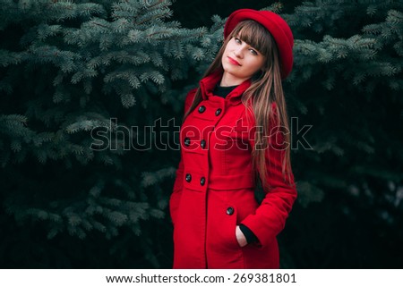 girl in red coat among trees