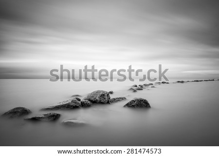Black and white long exposure shot of rocky path on the overcast day on the Gulf of Finland near Saint - Petersburg, Russia.