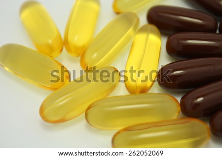 yellow and brown soft gel capsules isolated on white background