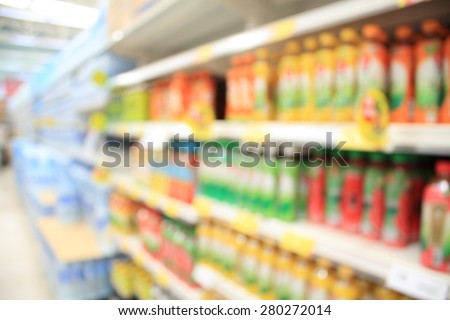 blur defocused of many different drink bottles on display on shelves in a supermarket